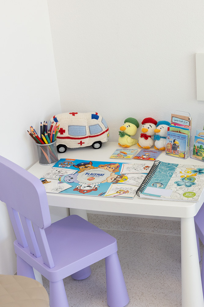 Kinderbereich im Wartezimmer mit Spieletisch und Sessel